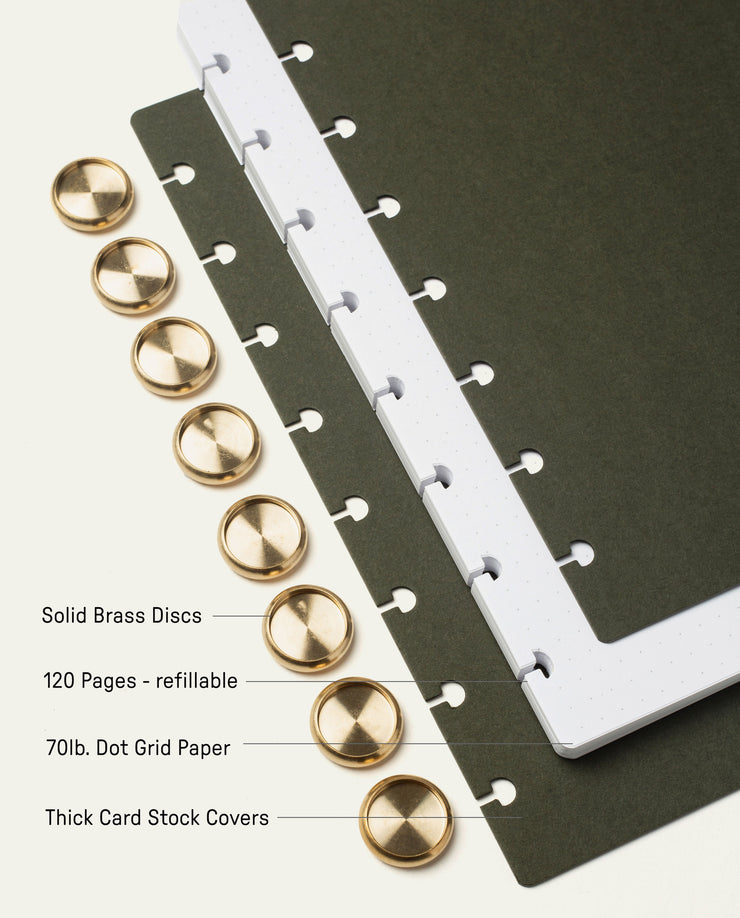 The Discbound Journal (Standard 6" x 8.5") features solid brass discs, thick card stock dark covers, and 120 refillable pages of 70lb white dot grid paper—perfect for note-taking and organization.
