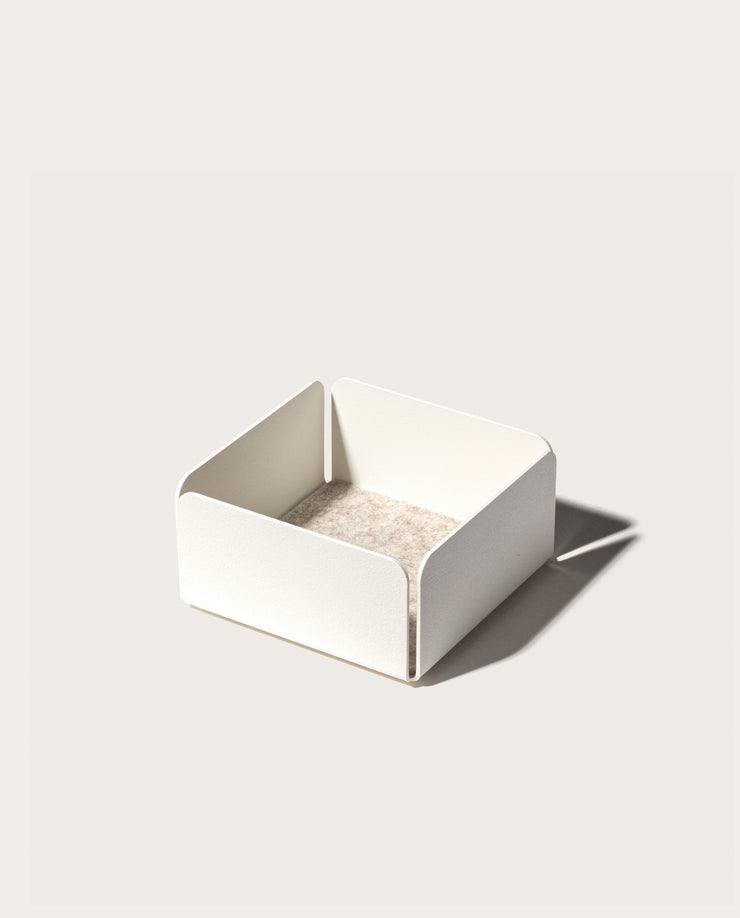 The Gather 2x2 Organizer Set (White) is a minimalist, powder-coated steel organizer with a square shape, rounded corners, and low sides. It features a light beige base and casts a right-side shadow on a plain background.