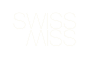 The image shows the word “SWISS” written in large, thin, white letters with its mirror image “SWISS” directly below, both on a very light gray background.