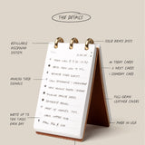 Desk calendar with stand and task list, labeled features on a beige background