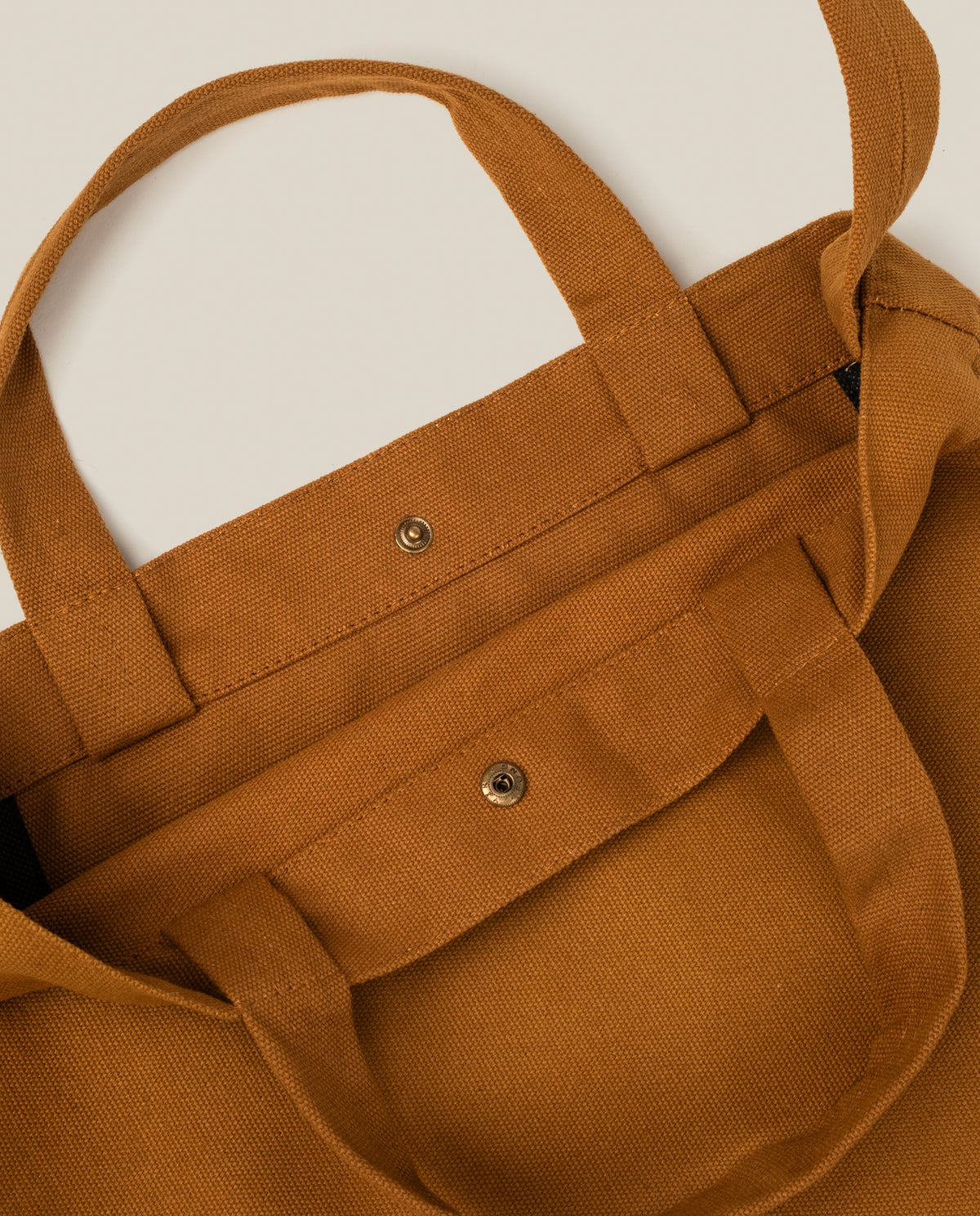 Ugmonk Utility Tote (Field Tan) made of sturdy tan canvas with two top handles and two metal snap buttons at the opening.
