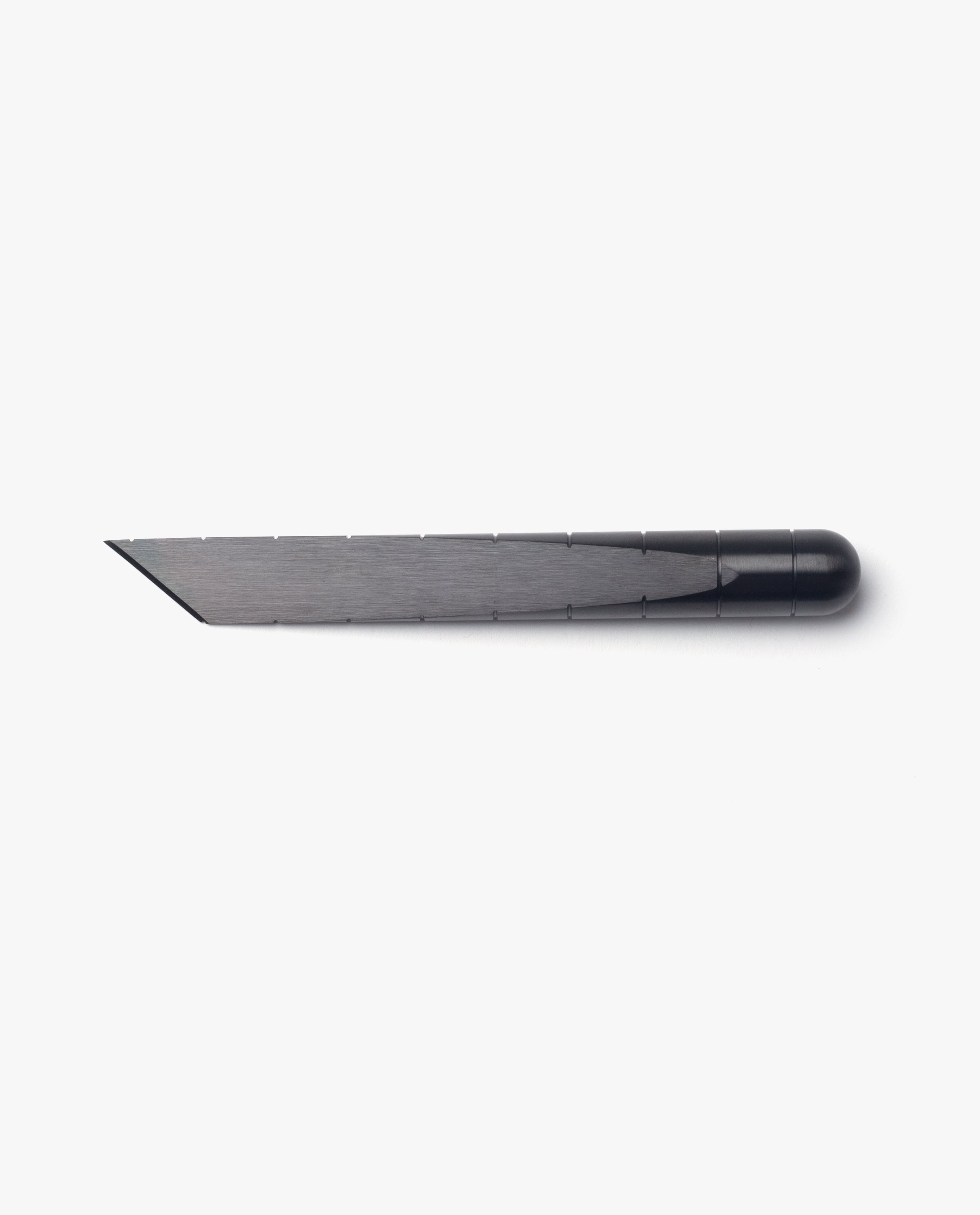 The Craighill Desk Knife (Vapor Black), shown on a white background, features a sleek stainless steel blade held in a black holder and offers precise cutting reminiscent of a Japanese kiridashi knife.