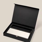 The Analog Weekly Planning Kit (Black Aluminum) features a sleek silver aluminum card stand with multiple rectangular buttons, nestled in a black foam insert inside an open black box set against a beige background.