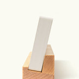 An Analog Weekly Planning Kit (Maple) stands vertically at an angle in a wooden holder, photographed from the side on a plain white background.