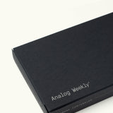 A sleek black rectangular box labeled "Analog Weekly Cards" in white text holds dot grid cards, with ugmonk.mom/analog displayed on the side.