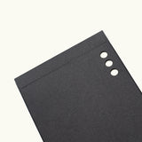 A set of Analog Weekly Cards, featuring black rectangular sheets with three round holes punched along the top right edge, resembling dot grid cards, displayed on a plain white background.