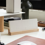 The Analog Premium Weekly Kit (Maple) includes blank white weekly planner cards in a maple wood holder, displayed on a tidy desk with a white mouse, keyboard, and office supplies.