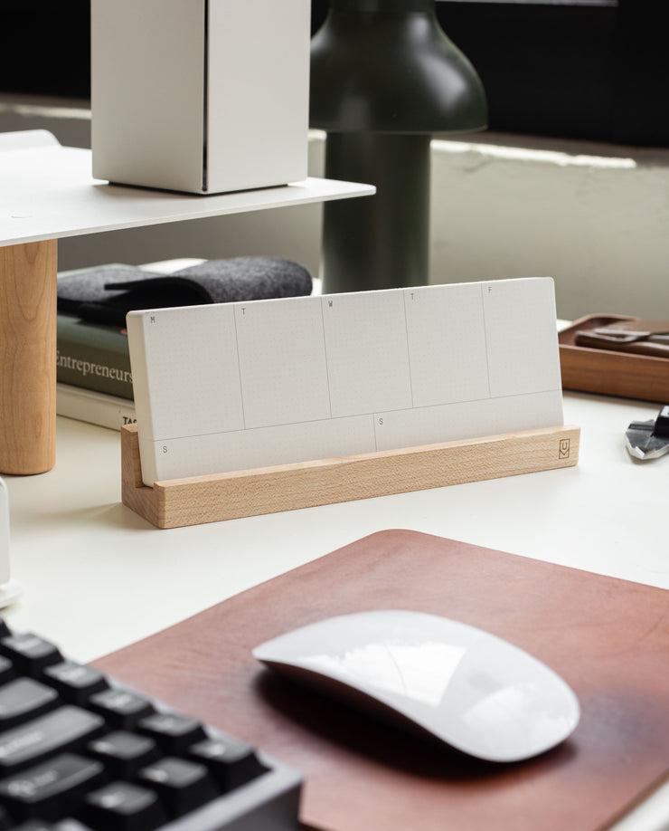 The Analog Premium Weekly Kit (Maple) includes blank white weekly planner cards in a maple wood holder, displayed on a tidy desk with a white mouse, keyboard, and office supplies.