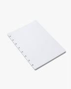 A stack of Discbound Journal Refill (Standard 6" x 8.5") white, loose-leaf dot grid pages with six disc-binding holes along the left edge, designed as a refill paper pack for your Heirloom Discbound Journal, placed on a plain white background.
