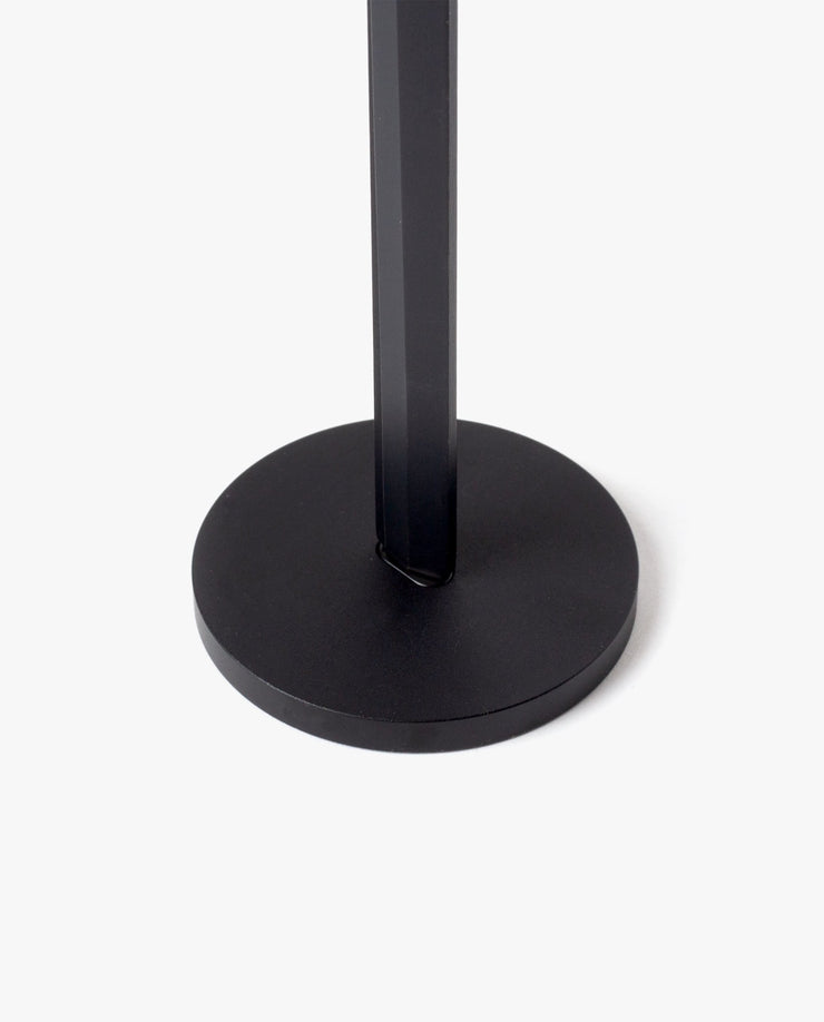 A close-up of the HMM Scissors (Black) shows its black, round magnetic metal base with a vertical pole at the center, set against a plain white background.