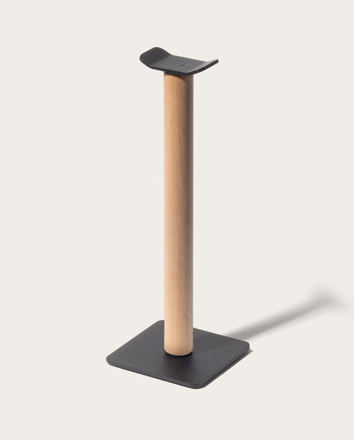 Introducing the Gather Headphone Stand (1x1 - Black/Maple), featuring a solid maple wood vertical post, a sleek black powder coated steel base, and a curved black top designed to elegantly display your headphones.