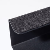 Close-up of the Gather Laptop Stand (Black/Walnut), featuring a black metal frame with a dark gray felt pad, an angular design, and a walnut accent. Made in the USA and set against a plain white background.