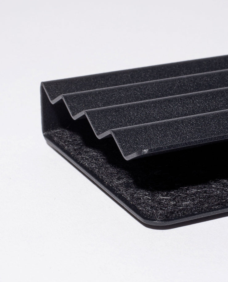 Close-up of the Gather Zigzag Tray (2x1 - Black) with four raised ridges and a wool felt-lined interior, showcasing its black textured surface and modern, minimalist design on a white background.