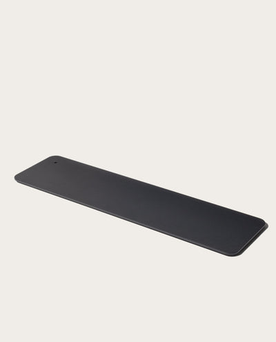 The Gather 1x4 Base Plate (Black) is a slim, rectangular wrist rest with rounded corners and a powder-coated steel base, designed for keyboard use and shown against a plain white background.