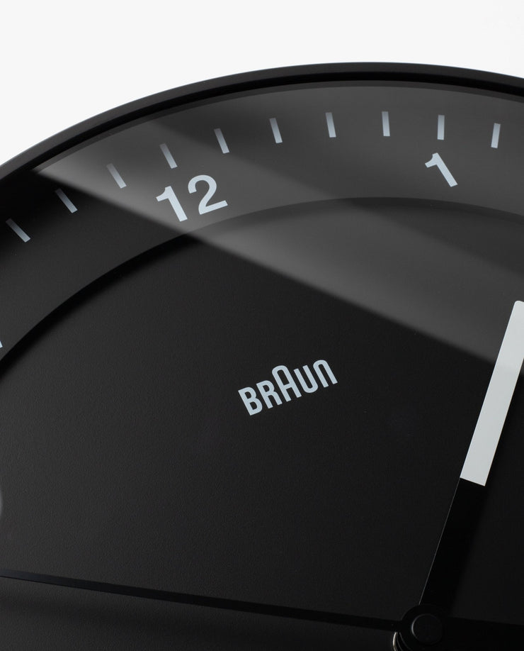 Close-up of the Braun Wall Clock (Black), featuring an easy-to-read minimalist design with white hands and bold numbers 11, 12, and 1.