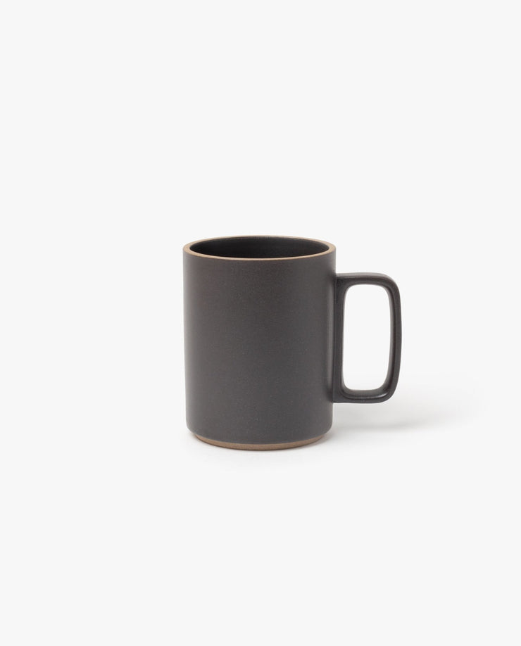 The Hasami Porcelain Mug (Matte Black) features a large rectangular handle and natural brown ceramic edges on the rim and base, highlighting its handmade look inspired by classic Japanese design. Photographed against a plain white background.
