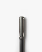 A close-up photo of the LAMY Lx Rollerball (Ruthenium) featuring a metallic clip on its cap, standing vertically against a plain white background. This refillable rollerball pen is designed for smooth writing, blending elegance and practicality.