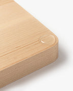 A close-up of the Valet Tray (Maple - Large) highlights its handcrafted solid maple construction, light wooden surface, and smoothly rounded corner, with a single water droplet visible near the edge.