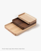 A handcrafted rectangular Valet Tray (Maple - Large) shown stacked slightly offset with other sizes and colors—solid maple, walnut, and maple—on a white background, perfect for use as a stylish valet tray set.