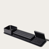 The Gather 1x4 Organizer Set (Black) is a sleek, modular desk organizer made in Pennsylvania with powder-coated steel compartments, a central grooved tray, left-side bin, and felt-lined angled sections on a rectangular base.