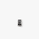 The Ugmonk Enamel Pin is a small, rectangular metallic accessory featuring a minimalist design with geometric U and M shapes on a plain white background.