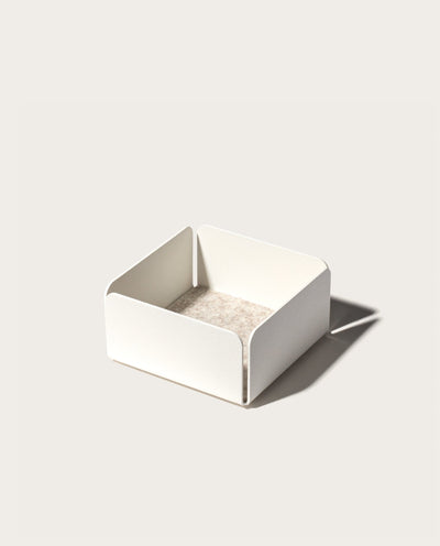 The Gather Small Tray (1x1 - White) features a minimalist white square design with open sides, rounded corners, and a beige interior. Made in Pennsylvania, it’s ideal as a desk organizer and casts a right-side shadow on light surfaces.