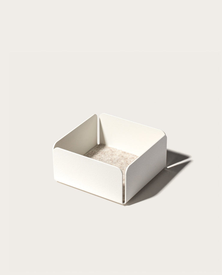 The Gather Small Tray (1x1 - White) features a minimalist white square design with open sides, rounded corners, and a beige interior. Made in Pennsylvania, it’s ideal as a desk organizer and casts a right-side shadow on light surfaces.