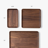The Valet Tray (Walnut - Small), handcrafted in Pennsylvania, measures 4.25" x 7.5". Perfect for everyday carry storage, it’s displayed alongside medium (7.5" x 7.5") and large (11.5" x 7.5") trays on a white background.
