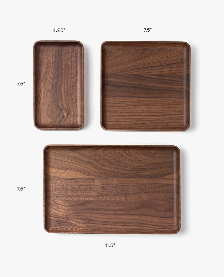 The Valet Tray (Walnut - Small), handcrafted in Pennsylvania, measures 4.25" x 7.5". Perfect for everyday carry storage, it’s displayed alongside medium (7.5" x 7.5") and large (11.5" x 7.5") trays on a white background.