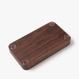 The Valet Tray (Walnut - Small) is a handcrafted rectangular tray made in Pennsylvania, featuring rounded edges, four clear rubber feet at each corner, and UGMONK engraved in the center—ideal for organizing your everyday essentials.