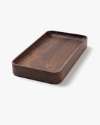 The Valet Tray (Walnut - Small) is a handcrafted, rectangular tray with rounded edges and a smooth dark walnut finish, made in Pennsylvania—ideal for storing everyday essentials. Shown on a plain white background.