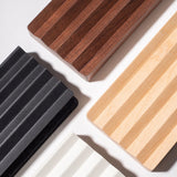 Four rectangular Gather Wood Zigzag Trays (2x1 - Walnut) with ribbed textures and varied colors are arranged diagonally on a white surface, their shadows adding dimension and highlighting the solid walnut option.