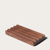 The Gather Wood Zigzag Tray (2x1 - Walnut) is a rectangular, dark solid walnut tray with three evenly spaced top grooves in a minimalist stepped design, shown on a plain light background.
