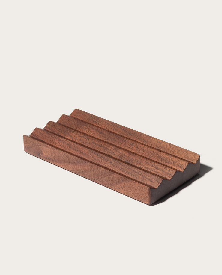 The Gather Wood Zigzag Tray (2x1 - Walnut) is a rectangular, dark solid walnut tray with three evenly spaced top grooves in a minimalist stepped design, shown on a plain light background.